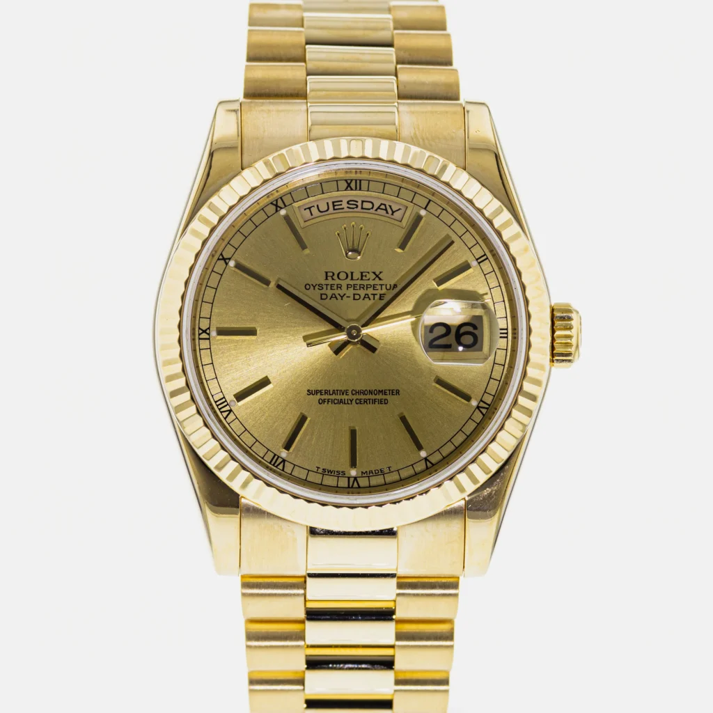 Gold Rolex Day-Date President 118238 wristwatch showing Tuesday and the date 26, featuring a fluted bezel and luxurious gold bracelet.