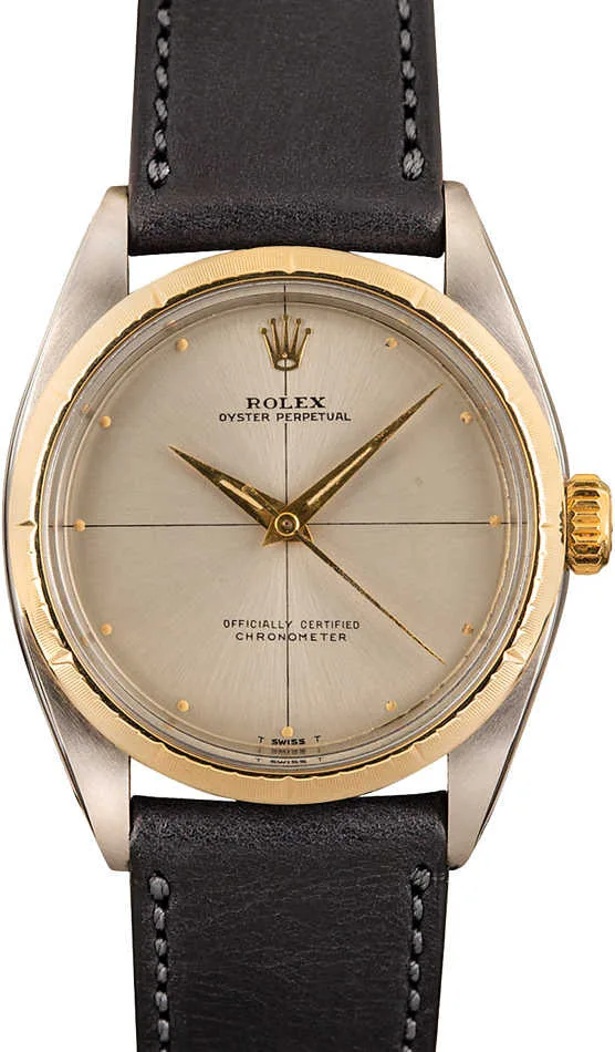 A Rolex Oyster Perpetual 6592 watch featuring a gold bezel, silver dial, and black leather strap.