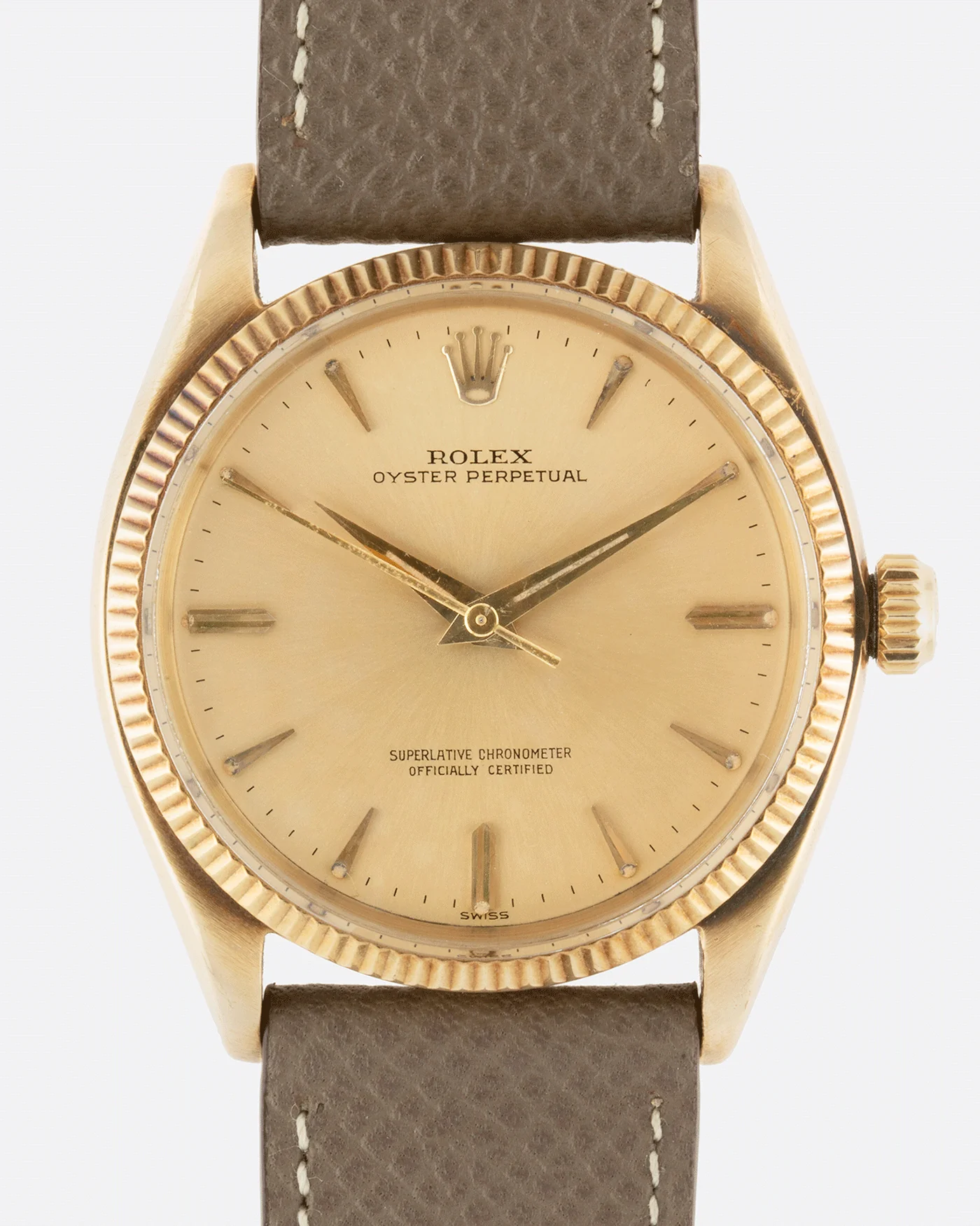 A gold Rolex Oyster Perpetual 1005 watch with a brown leather strap and a simple, classic dial.