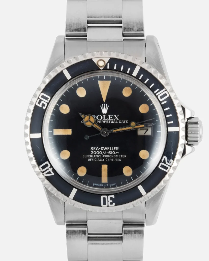 A vintage Rolex Sea-Dweller 1665 watch featuring a black dial, date window, and stainless steel band.