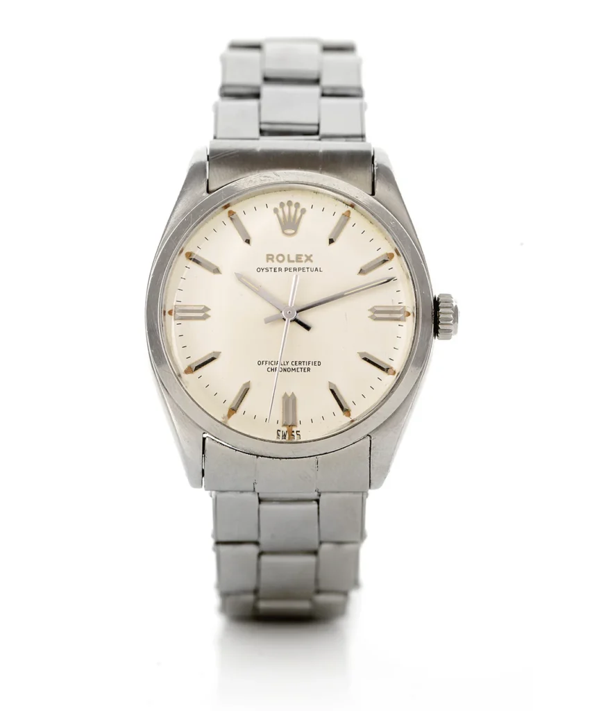 A silver Rolex Oyster Perpetual 6554 wristwatch featuring a white dial and sleek metal link band.