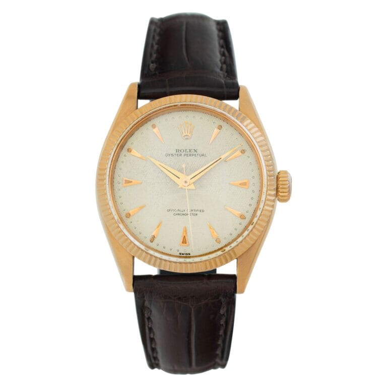 Gold Rolex Oyster Perpetual wristwatch, reference 6285, featuring a white dial, brown leather strap, and gold hour markers.