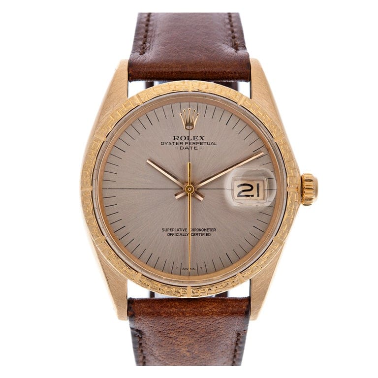 Gold Rolex Oyster Perpetual Date 1506 watch featuring a brown leather strap and gray dial displaying the date.