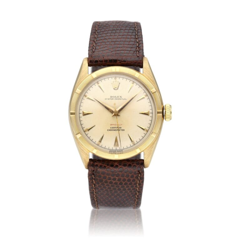 Gold Rolex Oyster Perpetual 6085 watch with a brown textured leather strap and a cream dial, shown against a white background.