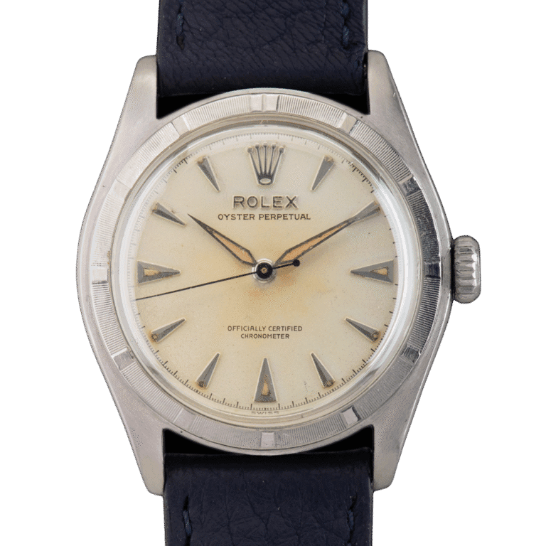 A vintage Rolex Oyster Perpetual 6107 watch featuring a cream dial and black leather strap.