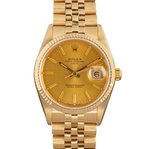 A gold Rolex Oyster Perpetual Date 15238 wristwatch featuring a date display and a classic linked bracelet band.