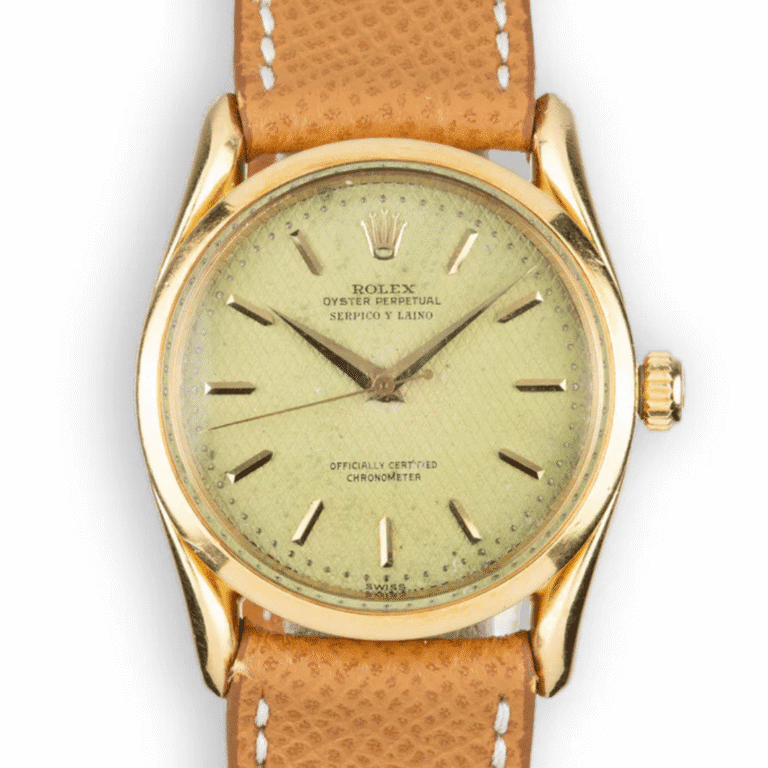 A vintage gold Rolex Oyster Perpetual 6290 watch with a tan leather strap and a light green dial.