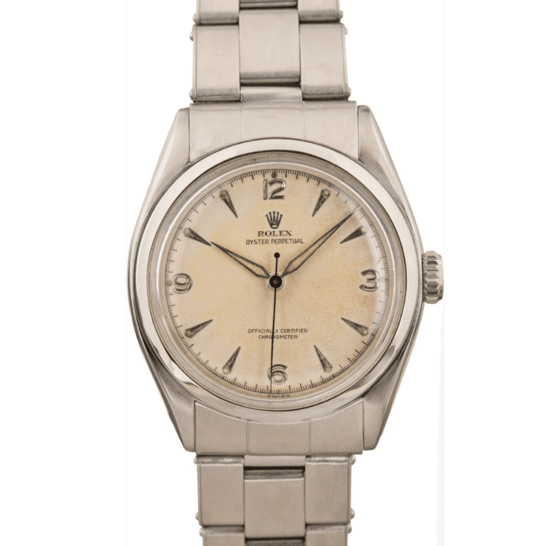 A vintage Rolex Oyster Perpetual 6084 silver watch with a cream dial and metal bracelet.