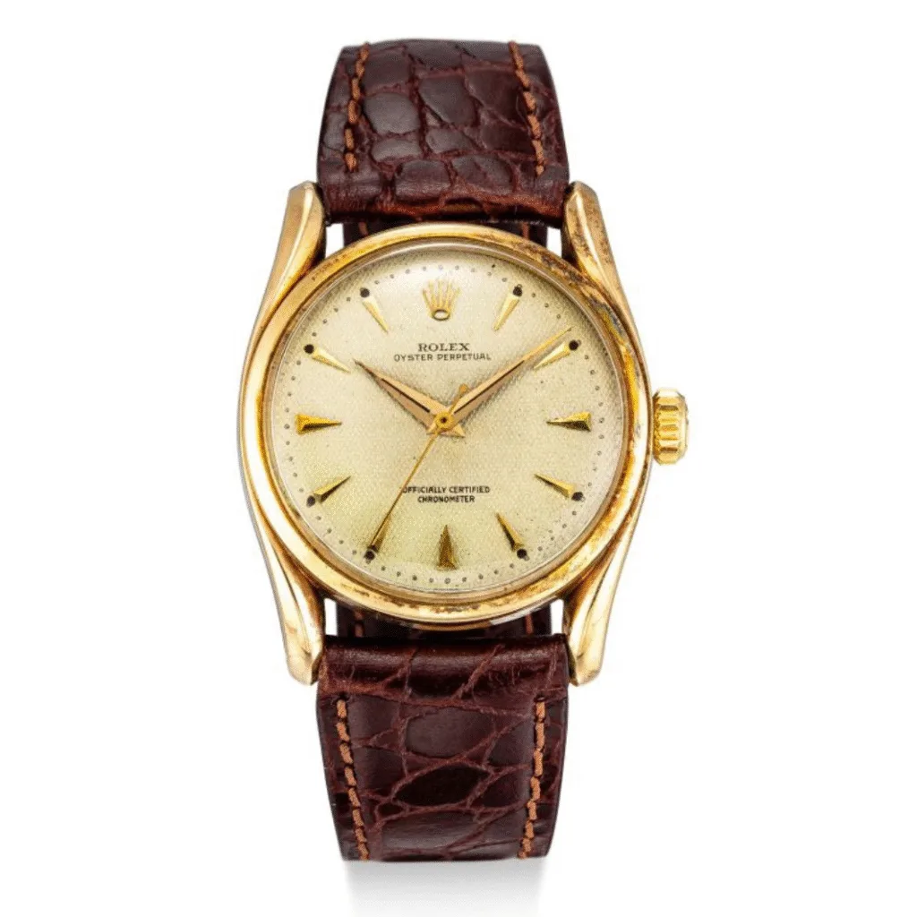 Vintage gold Rolex Oyster Perpetual 6102 watch with a textured brown leather strap and a light gold dial.