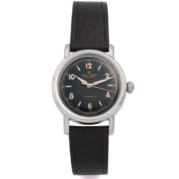 A vintage Rolex wristwatch with a black leather strap and a black dial displaying silver hands and numerals, reminiscent of the timeless elegance found in classic models like the Rolex Oyster.