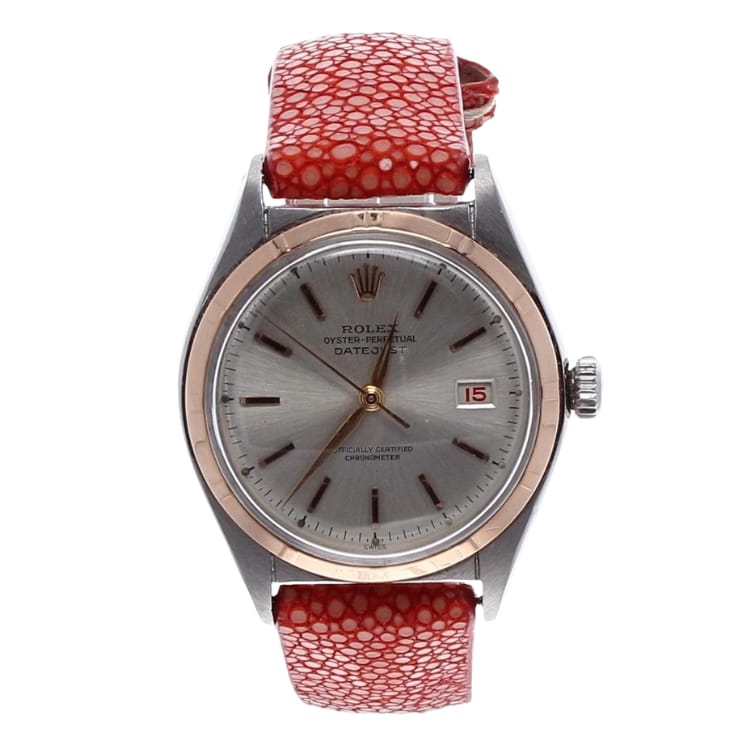 A silver Rolex Oyster Perpetual watch with a red textured strap and a Date 5075 display at 3 o’clock.