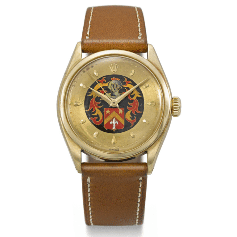 Gold Rolex Oyster Perpetual wristwatch with a brown leather strap and a colorful family crest on the watch face, inspired by the classic 6100 model.