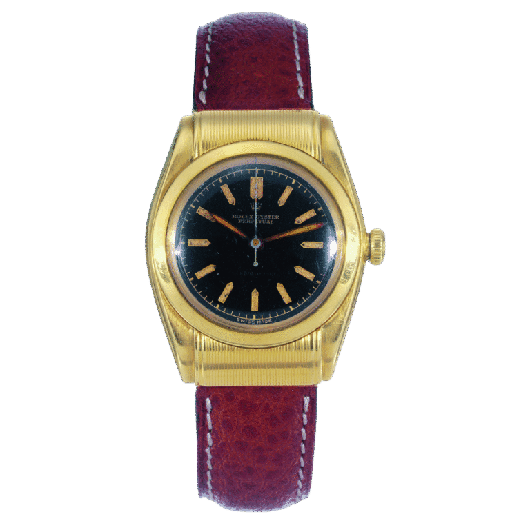 Gold Rolex Oyster Perpetual wristwatch with a black dial and red leather strap, viewed from above on a plain background.