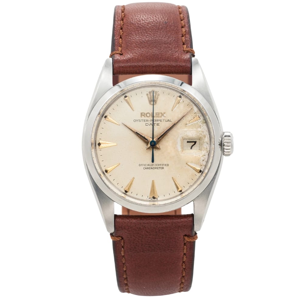 Vintage Rolex Oyster Perpetual Date 6530 watch with a brown leather strap and beige dial displaying the date at the 3 o’clock position.