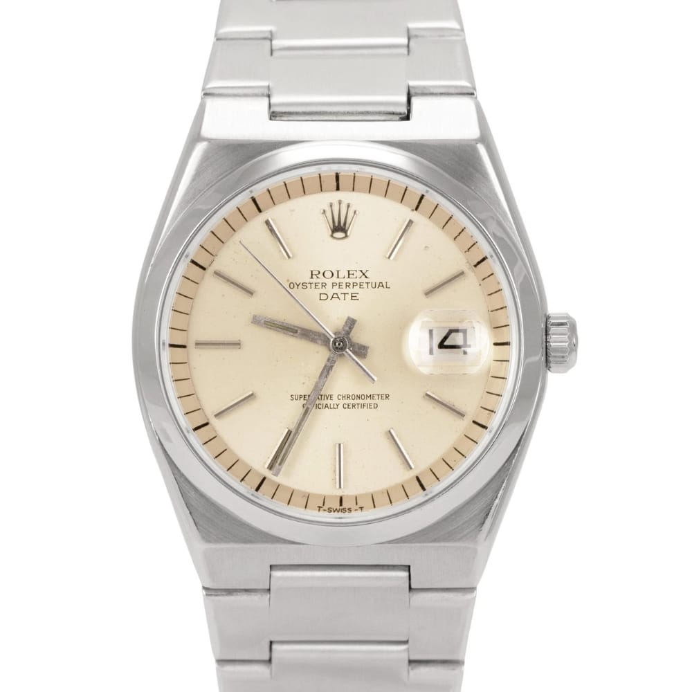A silver Rolex Oyster Perpetual Date 1530 watch with a cream dial and a metal link bracelet.
