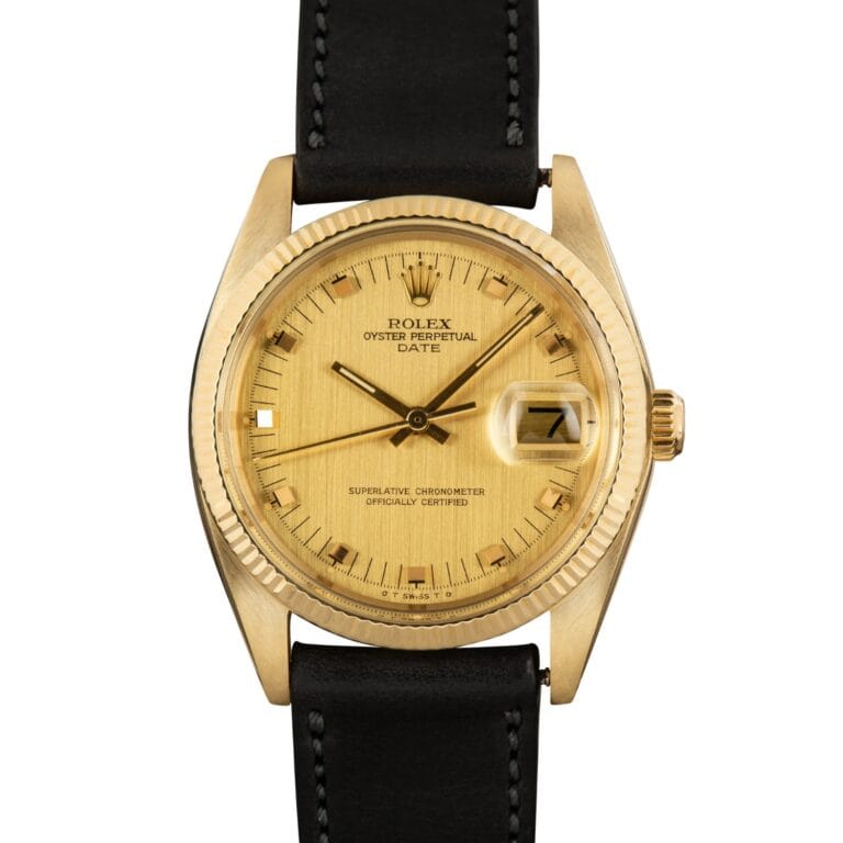 A gold Rolex Oyster Perpetual Date 1503 wristwatch with a black leather strap and date display, shown against a white background.