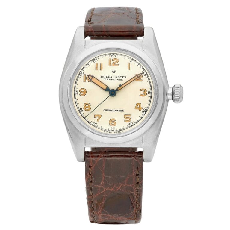 Vintage Rolex Oyster Perpetual Date 1102 watch featuring a cream dial, brown leather strap, and classic Arabic numerals.