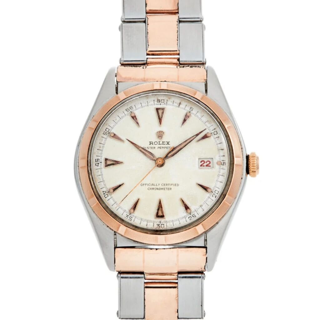 A two-tone Rolex Oyster Perpetual watch with a silver and rose gold band, white dial, and date display at 3 oclock.