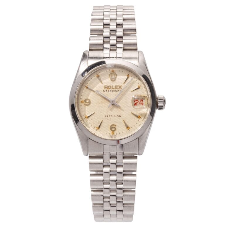Silver Rolex Oysterdate wristwatch with a metal band, cream dial, and the date highlighted in red at the 3 o’clock position.