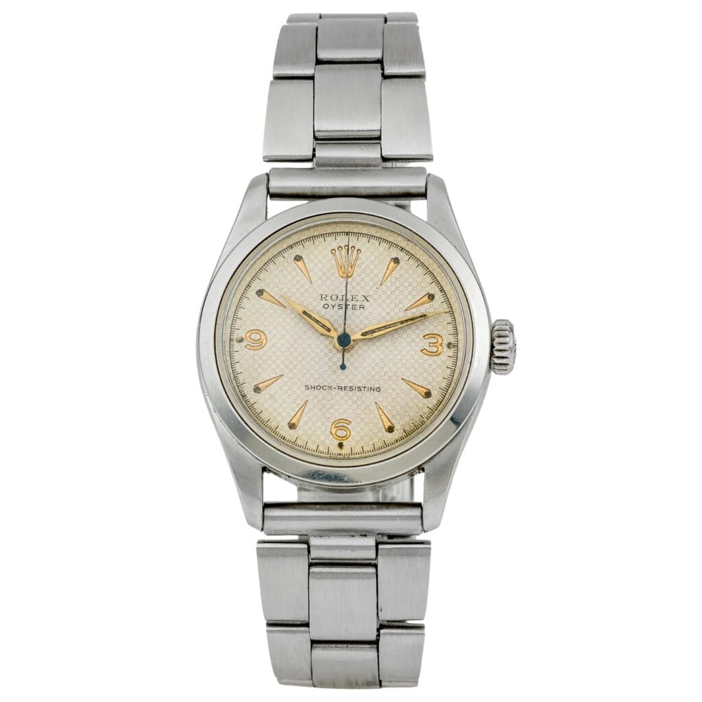 A vintage Rolex Oyster wristwatch with a stainless steel band and a cream-colored dial, this classic timepiece embodies the timeless elegance of the iconic Rolex 6244 model.