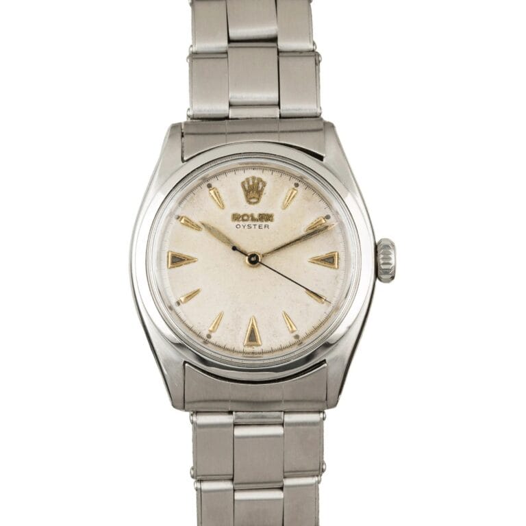 A vintage Rolex Oyster 6022 wristwatch with a silver metal band and a white dial featuring gold hour markers.