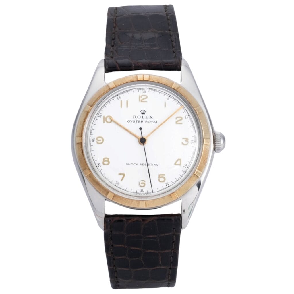 A Rolex Oyster Royal 5025 watch featuring a white dial, gold bezel, and black leather strap.