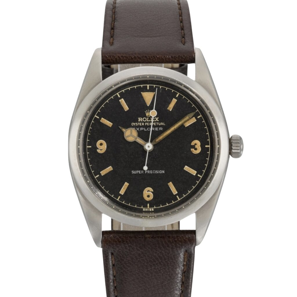 Vintage Rolex Explorer watch with a black dial, gold hour markers, and a brown leather strap—an iconic Rolex piece for collectors.