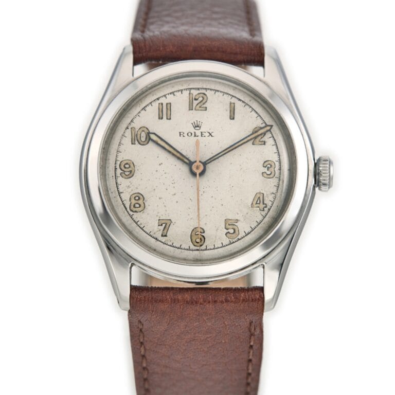 A vintage Rolex Oyster 4499 wristwatch with a brown leather strap and a silver dial displaying Arabic numerals.