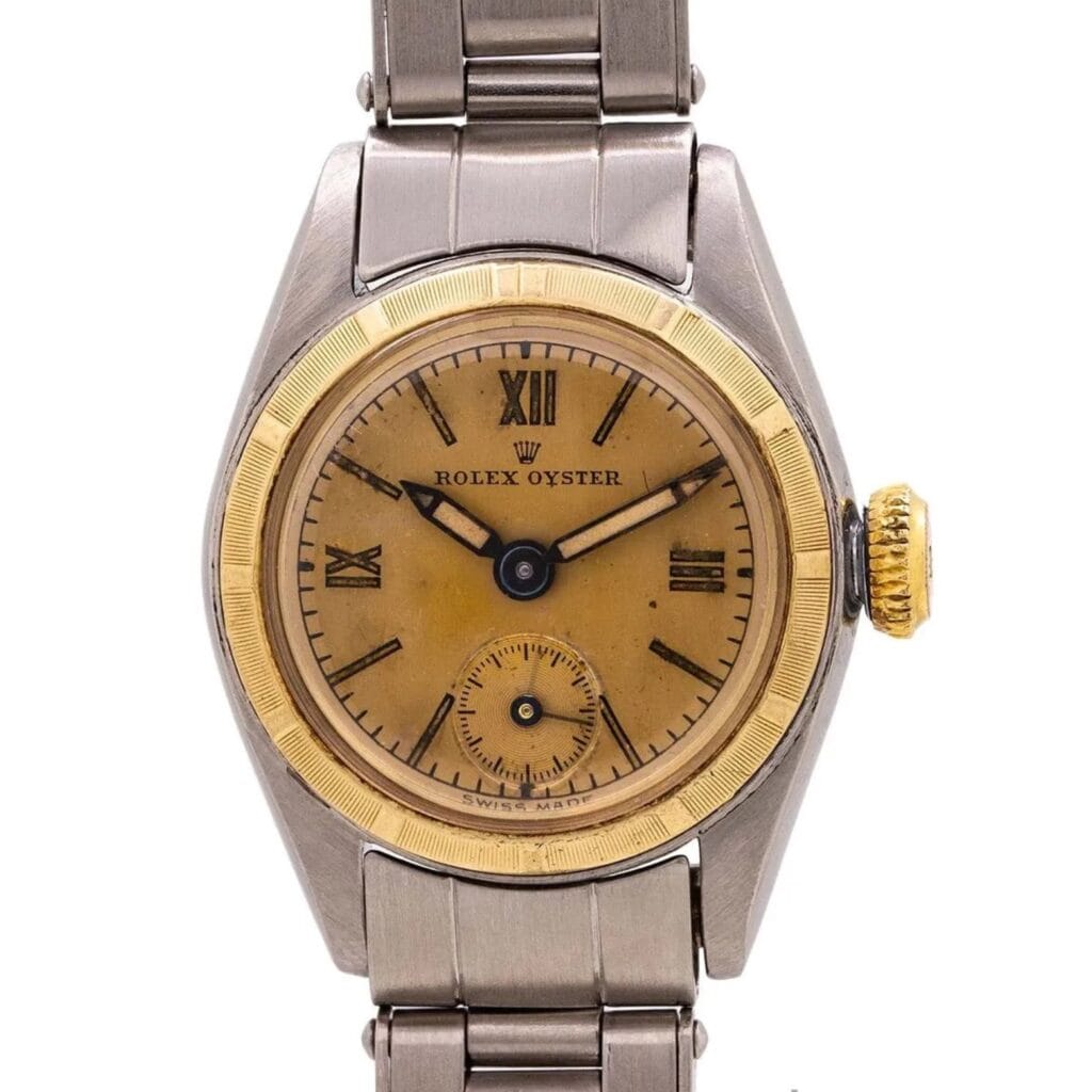 Vintage Rolex Oyster watch, model 4437, featuring a gold bezel, yellowed dial with Roman numerals, and a classic metal bracelet band.
