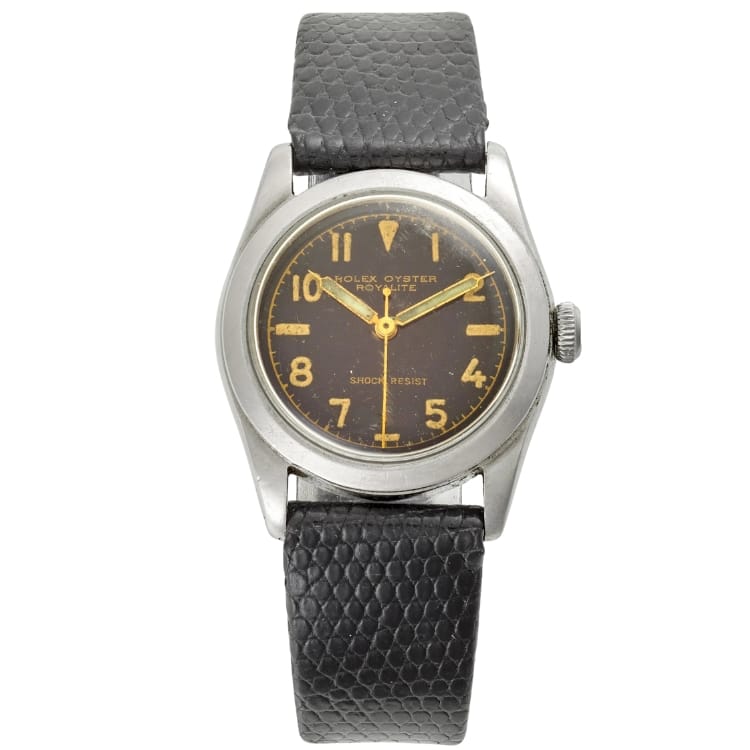 A vintage Rolex Oyster Speedking 4220 watch with a black dial, yellow numerals, and a black textured leather strap.