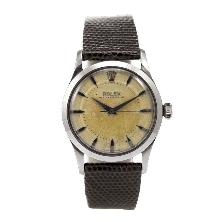 Vintage Rolex Oyster Perpetual wristwatch, ref. 6332, featuring a beige dial, black markers, and a textured dark leather strap.