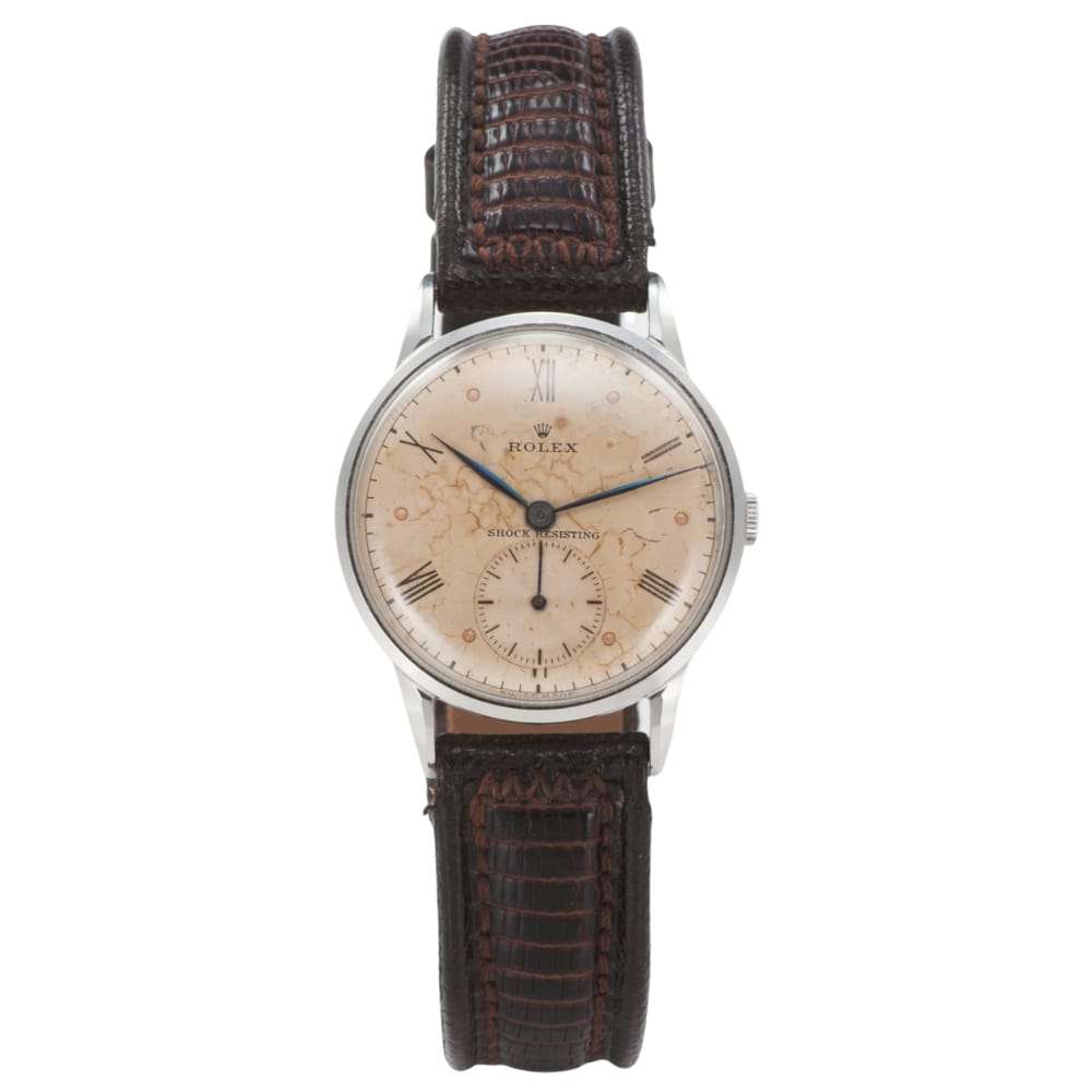 Vintage Rolex wristwatch with a worn, cream-colored dial and a dark brown textured leather strap.