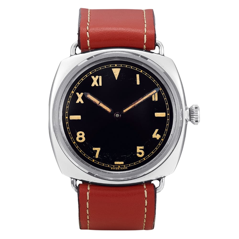 Wristwatch with a black dial, tan numbers, and a brown leather strap with white stitching.