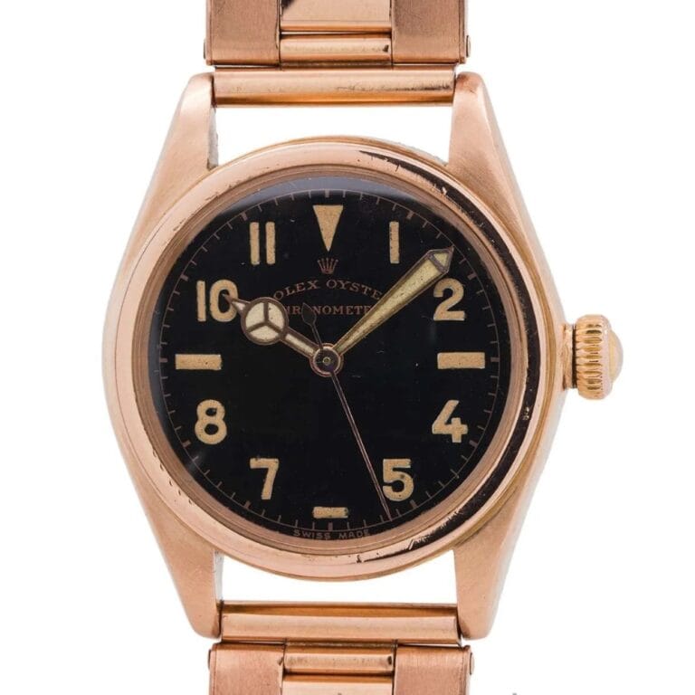 A vintage gold Rolex Oyster 2595 wristwatch with a black dial and gold numerals, showing the time 10:10.