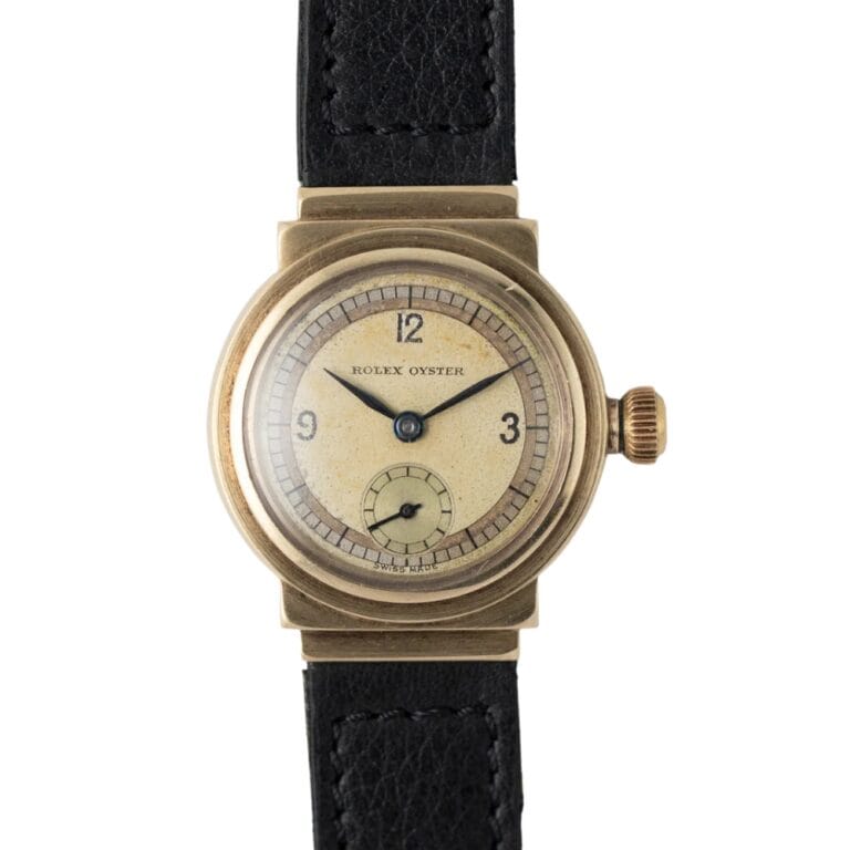 A vintage Rolex Oyster 2331 wristwatch with a gold case, cream dial, and black leather strap.