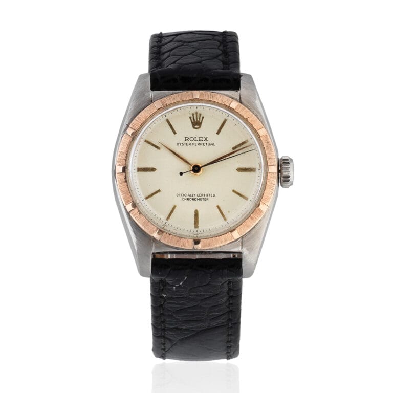 A vintage Rolex Oyster Perpetual wristwatch with a black leather strap and a round, white dial.