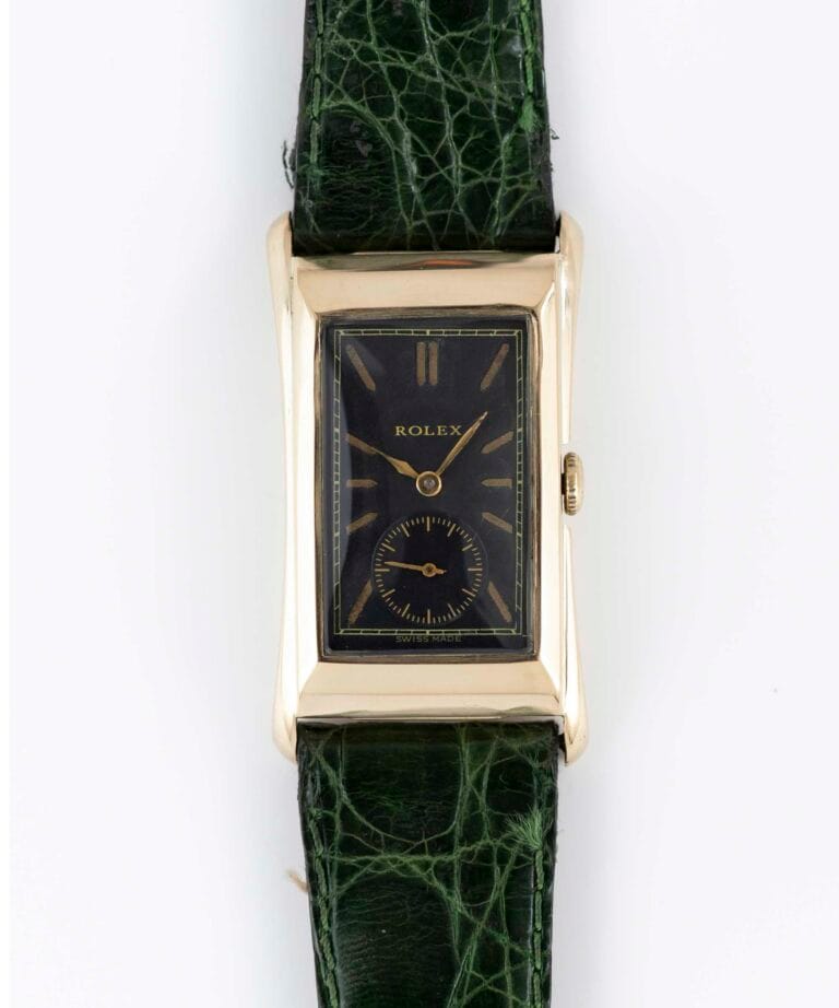 Rectangular gold vintage Rolex Prince watch with a black face and green textured leather strap, viewed from above.