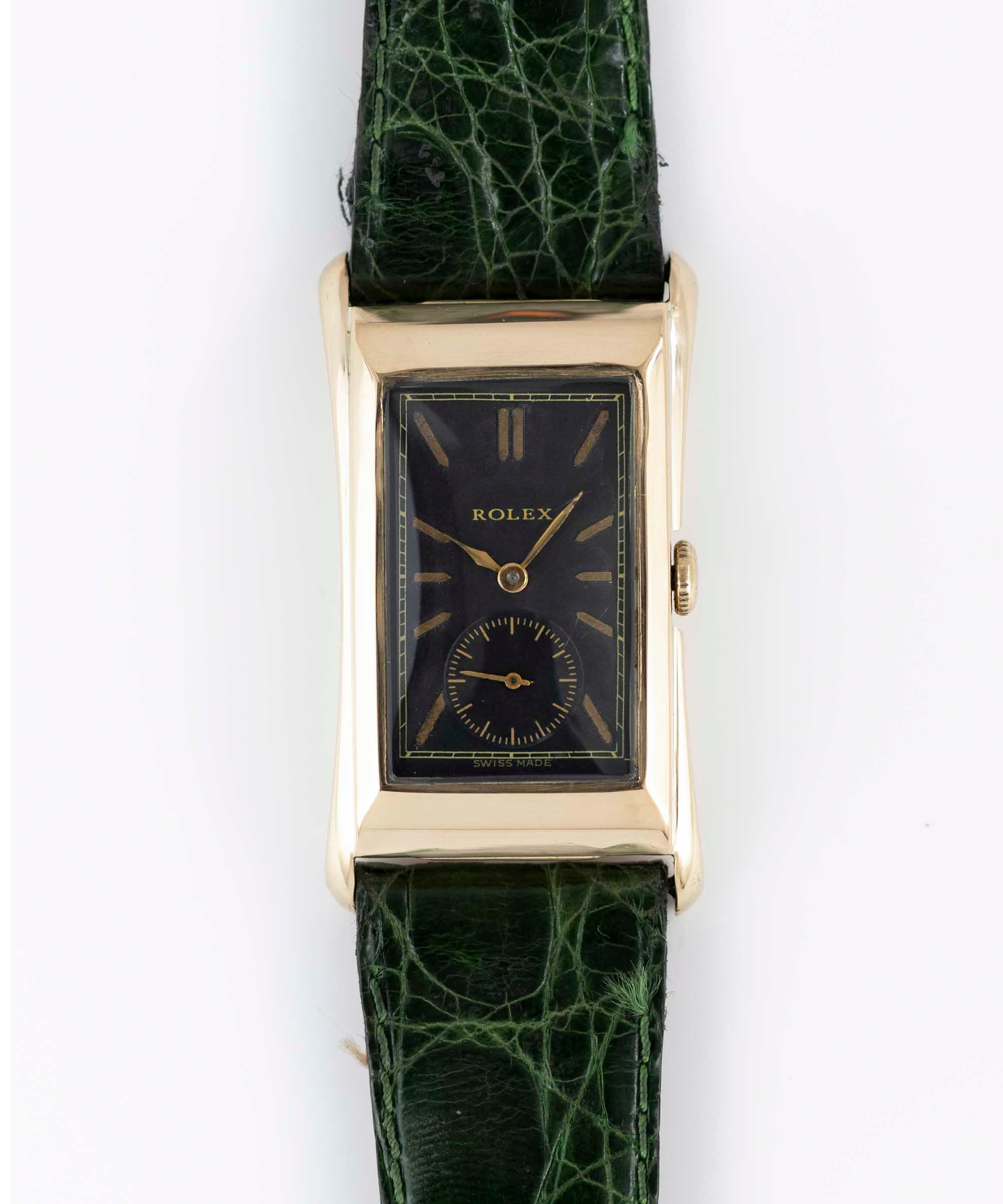 Rectangular gold vintage Rolex Prince watch with a black face and green textured leather strap, viewed from above.