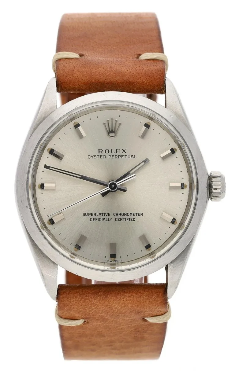 A silver Rolex Oyster Perpetual 6023 watch with a brown leather strap and simple black hour markers.