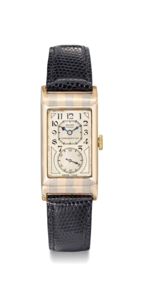 A rectangular vintage Rolex Prince wristwatch with a black leather strap and an off-white face displaying Arabic numerals.