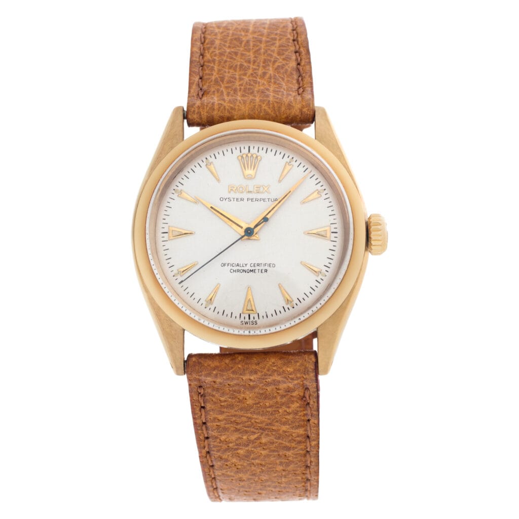 Gold Rolex Oyster Perpetual wristwatch, model 6584, with a white dial and brown leather strap, showing the time at 10:10.