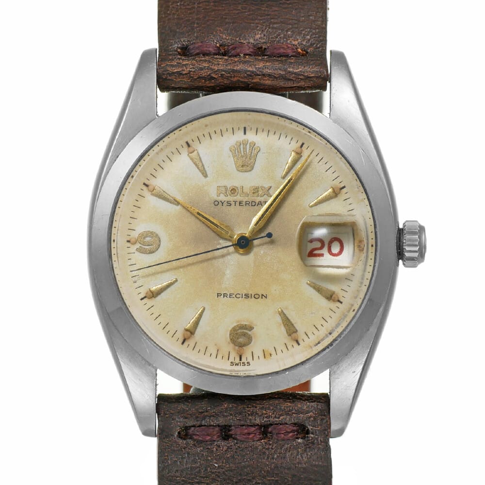 Vintage Rolex Oysterdate Precision 6494 watch with a brown leather strap, cream dial, and date window showing 20 in red.