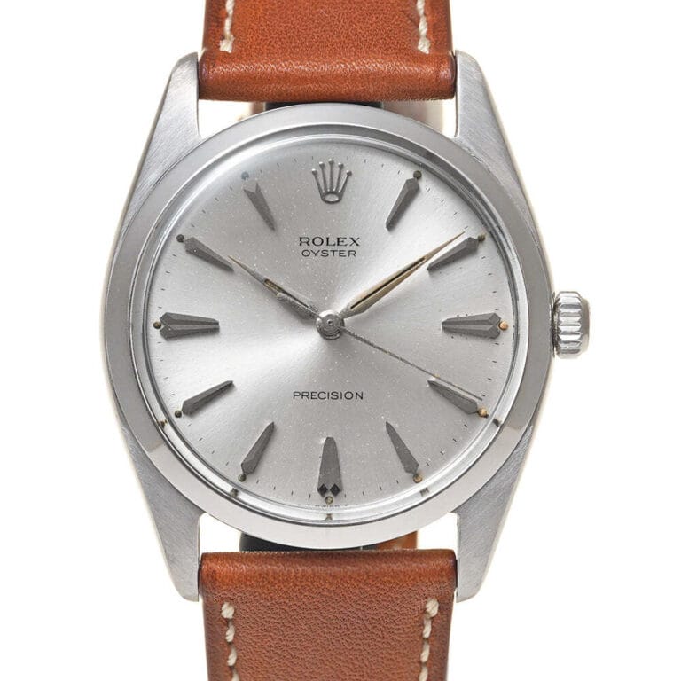 A silver Rolex Oyster Precision 6424 watch with a brown leather strap and simple, minimalist dial design.
