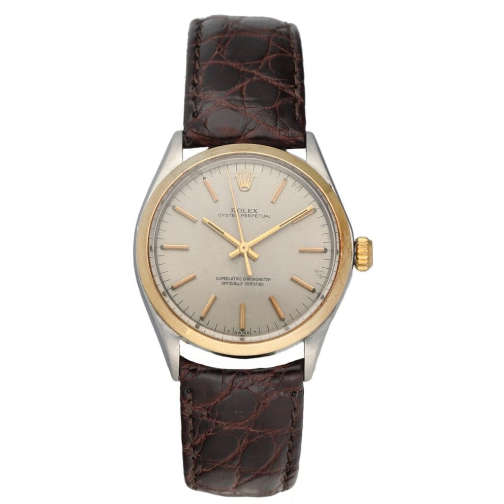 A classic Rolex Air King 1002 wristwatch featuring a brown leather strap and a silver dial with gold accents.