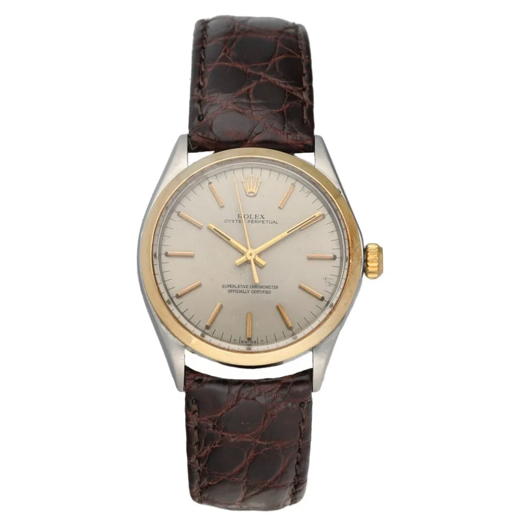 A classic Rolex Air King 1002 wristwatch featuring a brown leather strap and a silver dial with gold accents.