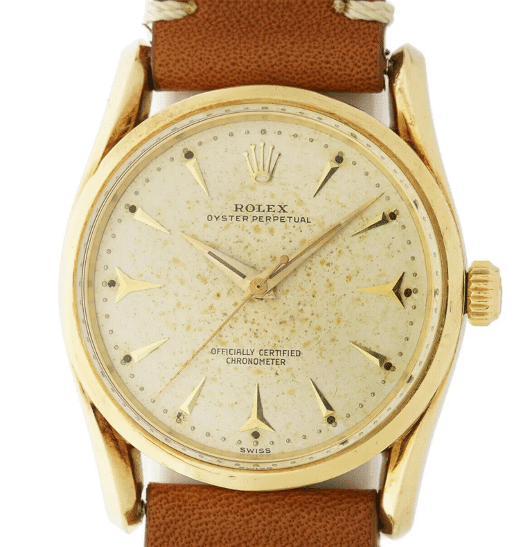 Vintage gold Rolex Oyster Perpetual 6590 watch with a brown leather strap and an aged, speckled dial.