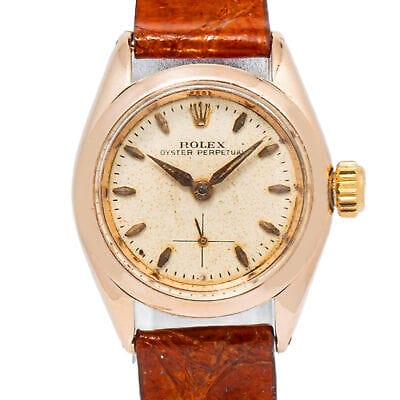 Vintage Rolex Oyster Perpetual 6504 watch featuring a brown leather strap and a classic gold case.