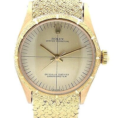 Gold Rolex Oyster Perpetual 6553 watch with a textured gold band and a simple, classic dial.