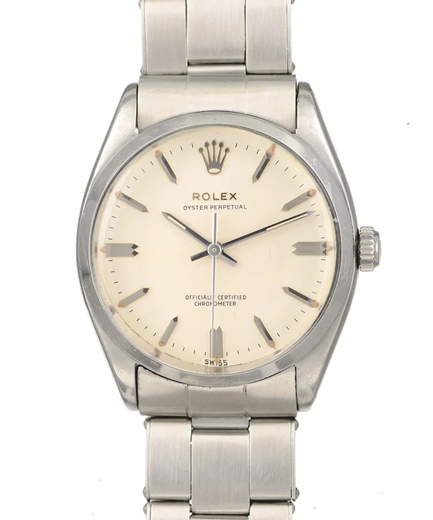 A silver Rolex Oyster Perpetual watch with a cream dial and metal bracelet.