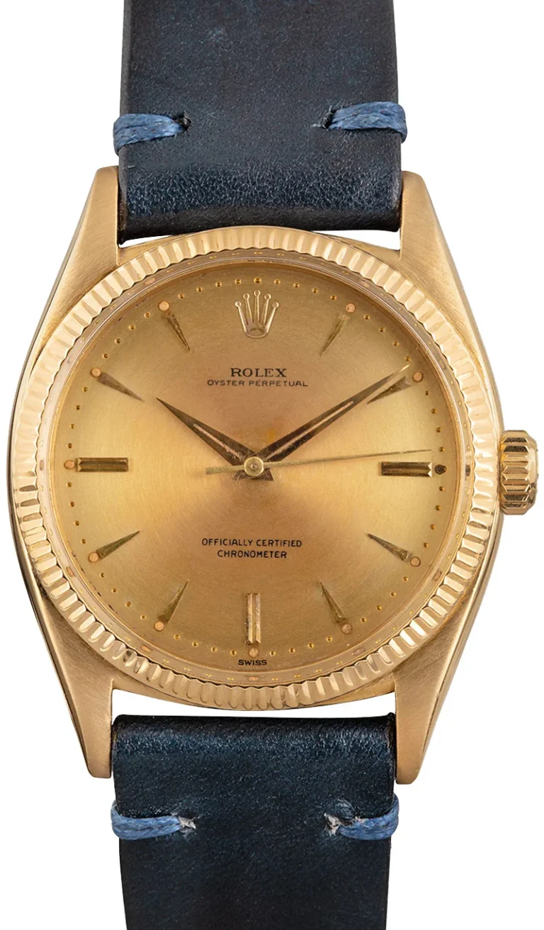 Rolex Oyster Perpetual 6599 gold watch with a black leather strap, gold dial, and simple hour markers.